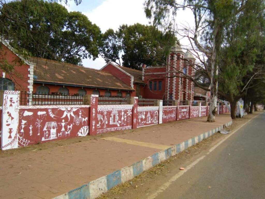 college road in dharwad karnataka with warli paintings and footpath with old training college in background