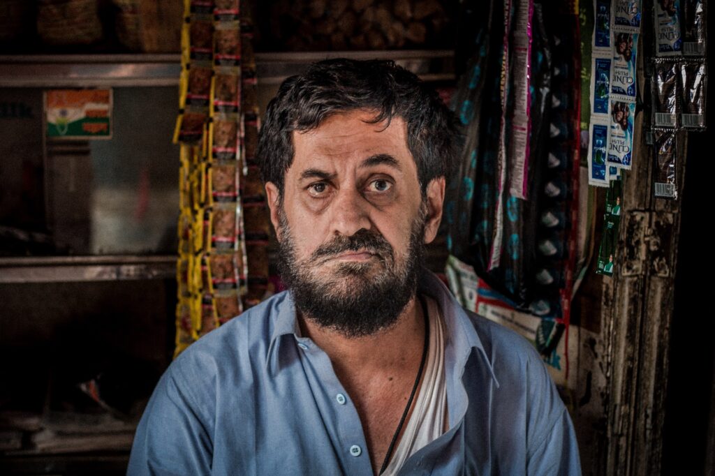 digruntled man vendor in small shop in mumbai india