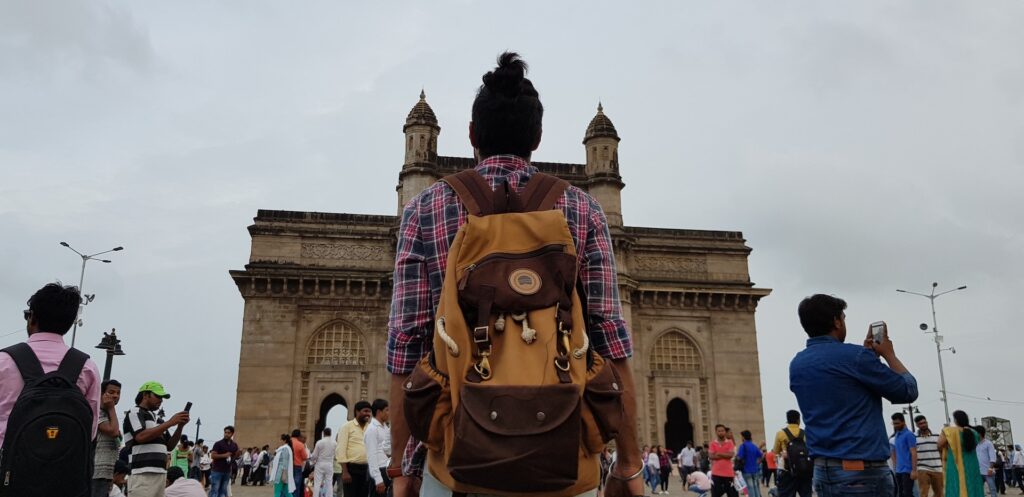 man with bag looking at gateway of india in mumbai colaba